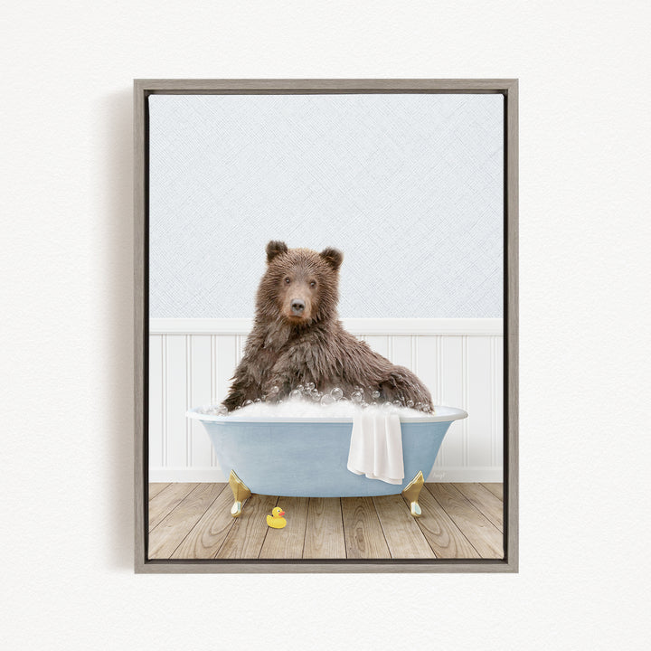 A brown bear sitting in a blue bathtub filled with water, surrounded by rubber ducks.