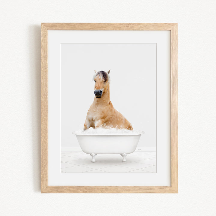 A brown horse sitting in a white bathtub filled with bubbles, looking directly at the camera.