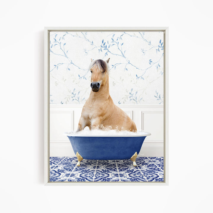 A light brown horse is sitting in a blue bathtub filled with water, surrounded by a blue and white patterned floor.