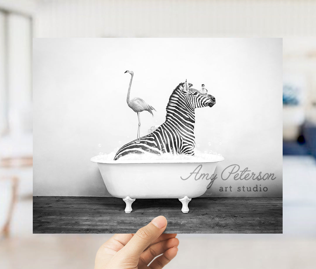 a hand holding a card with a zebra and a flamingo in a bathtub