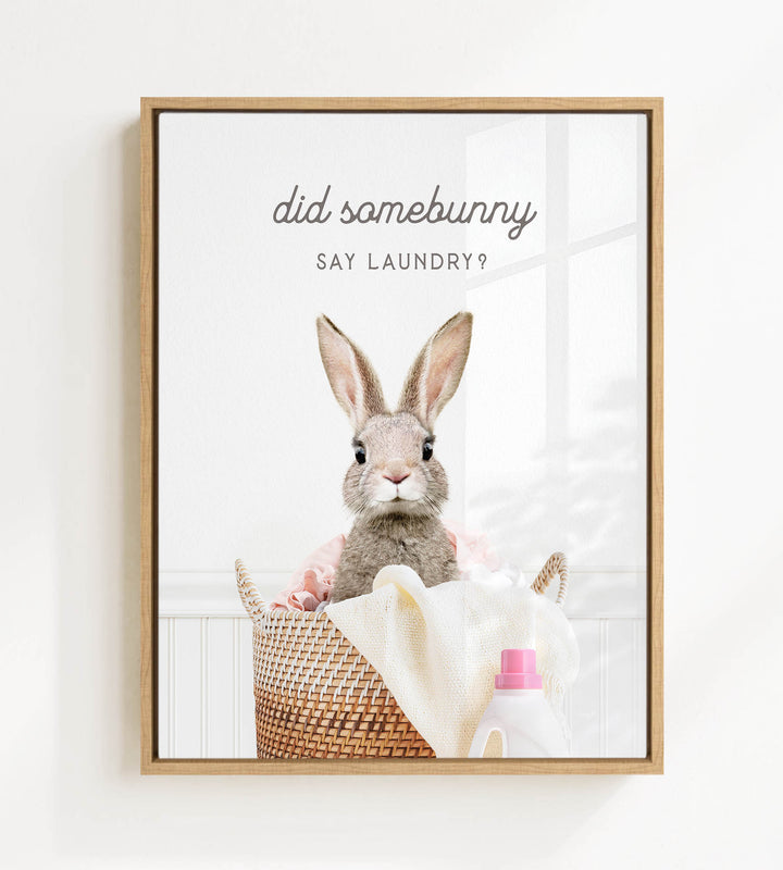 A framed image of a rabbit sitting in a basket filled with laundry, with the text "Did some bunny Say laundry?" displayed above the rabbit.