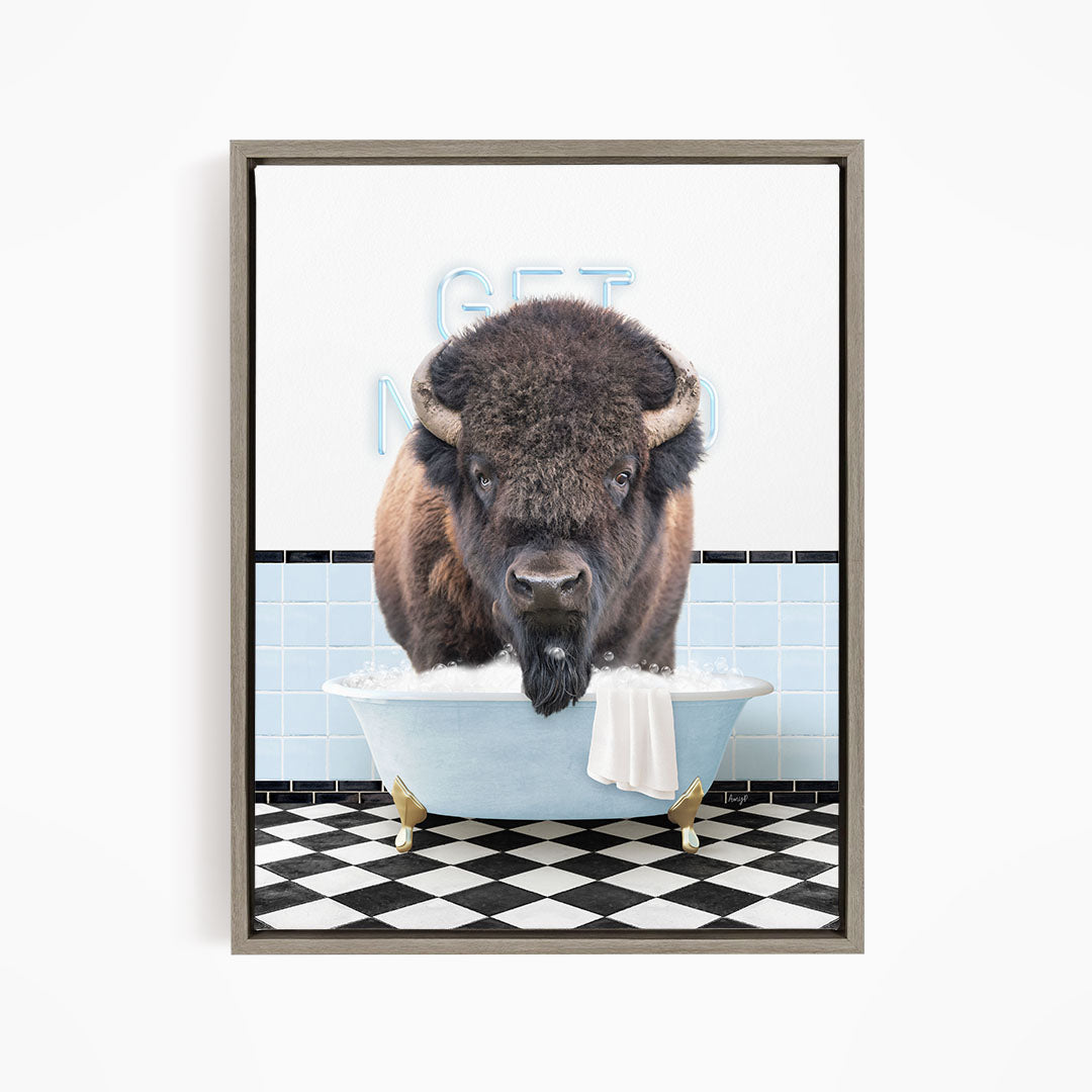 A buffalo standing in a bathtub filled with bubbles, with a sign that says "GET IN THE WASH".