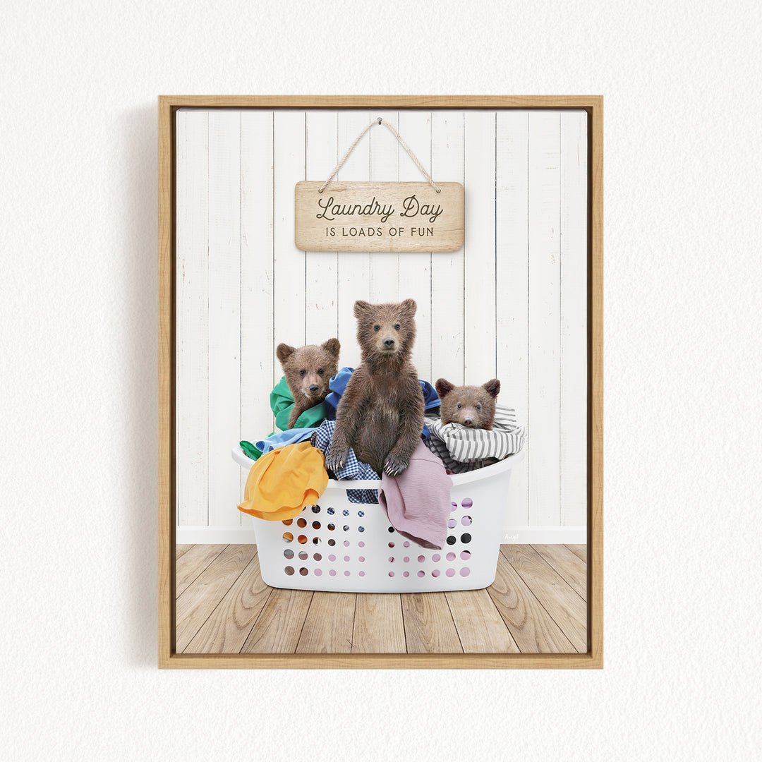A framed image of three bears sitting in a laundry basket, with a sign above them that says "Laundry Day is loads of fun".