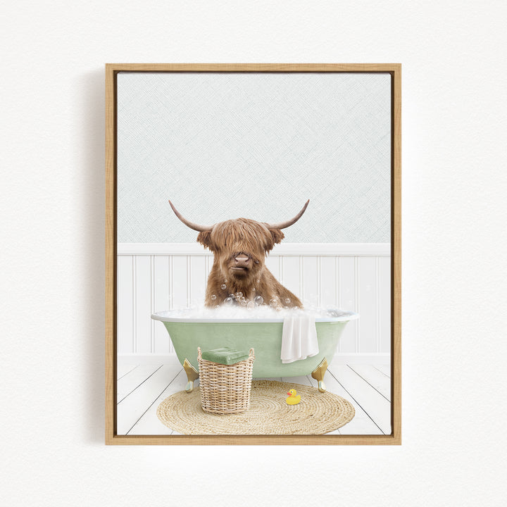 A brown cow with long horns is sitting in a green bathtub filled with bubbles, surrounded by a basket of rubber ducks and a towel.