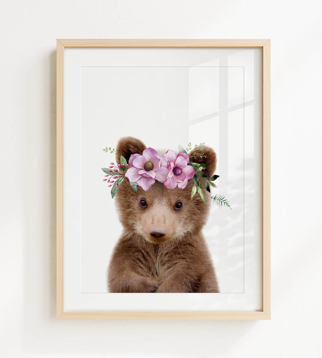 A framed print of a cute brown bear wearing a floral crown.