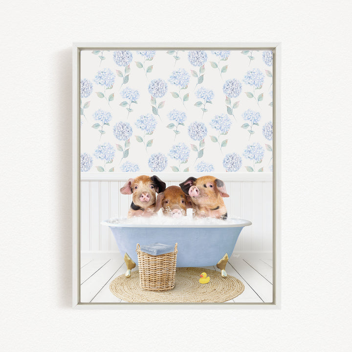 Three adorable pigs sitting in a blue bathtub, surrounded by a floral patterned wall and a basket of rubber ducks.