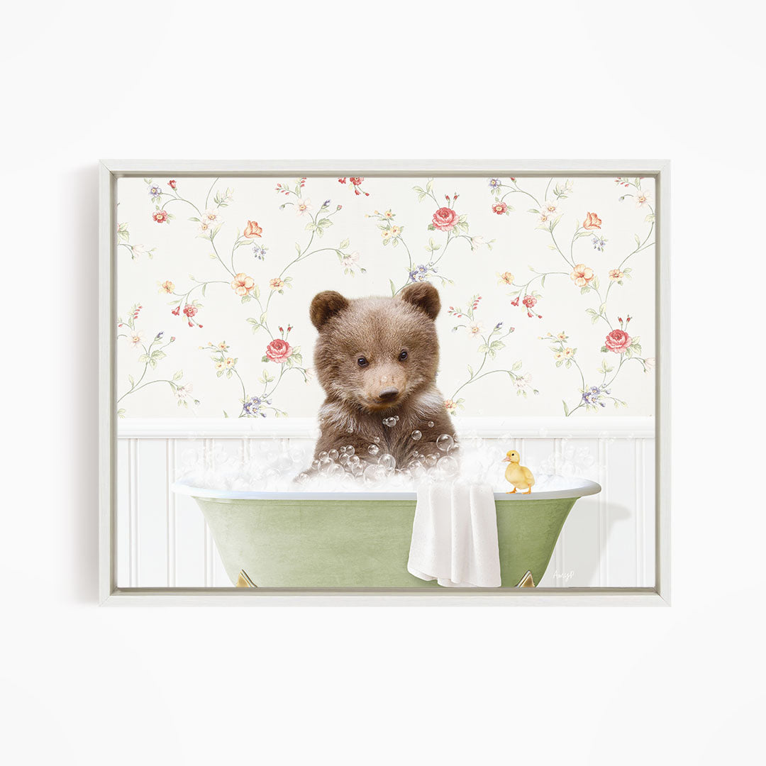 A cute brown bear sitting in a green bathtub filled with bubbles, with a yellow duck floating nearby.