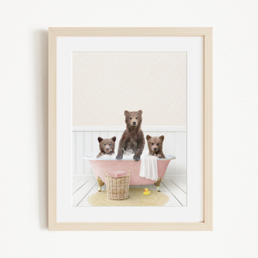 A framed image depicting three bears sitting in a pink bathtub, with a yellow rubber duck floating in the water.