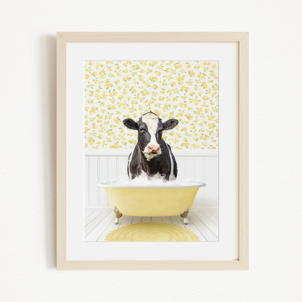 A black and white cow is sitting in a yellow bathtub filled with water, surrounded by a yellow floral pattern on the wall behind it.