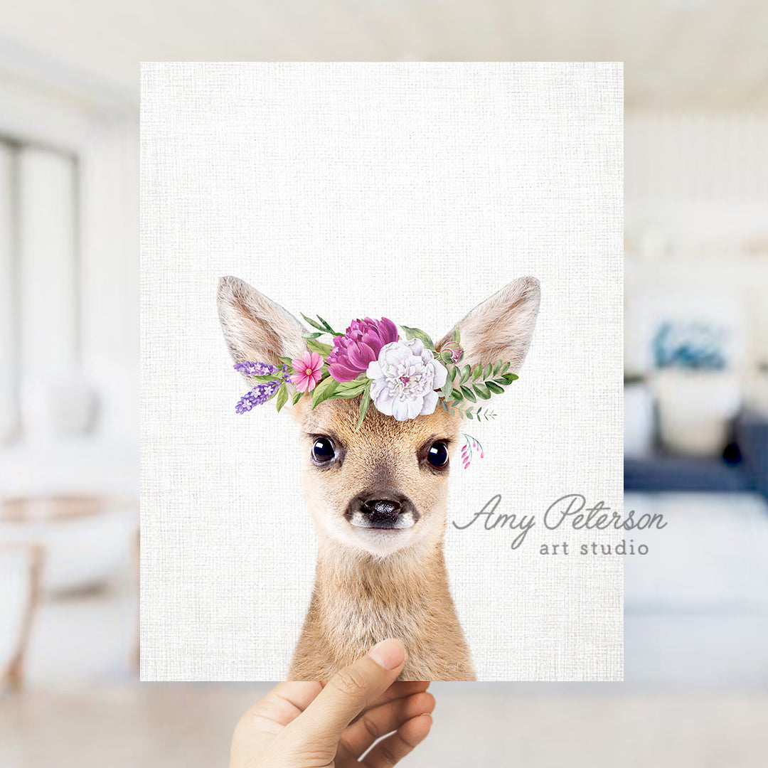 a person holding up a card with a picture of a deer wearing a flower crown