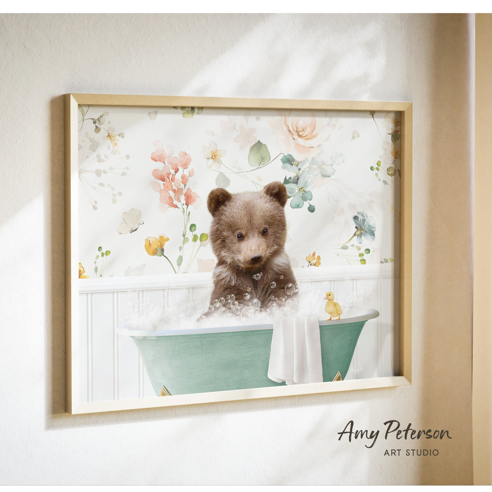 A framed print of a brown bear sitting in a green bathtub filled with bubbles, surrounded by a floral pattern.