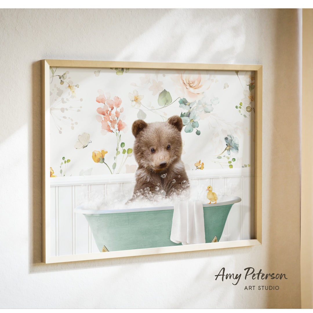 A framed print of a brown bear sitting in a green bathtub filled with bubbles, surrounded by a floral pattern.