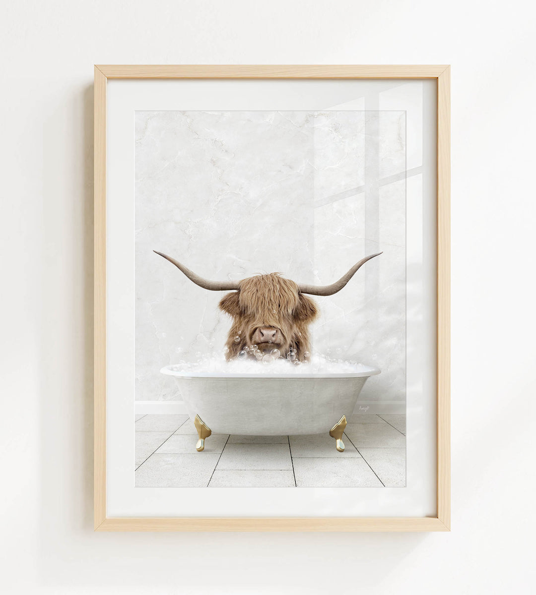 A framed image depicting a Highland cow with long horns sitting in a white bathtub filled with water.
