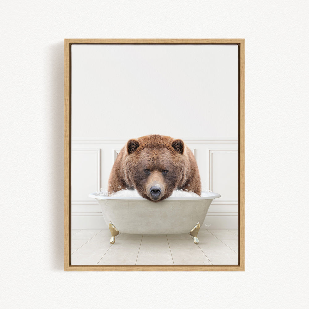 A brown bear is sitting in a white bathtub filled with water, appearing to enjoy the bath.