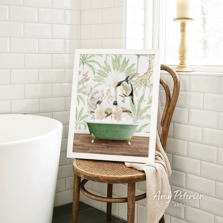 A framed painting of a green bathtub with animals, including a penguin, giraffe, and other animals, is displayed on a wooden chair in a bathroom setting.