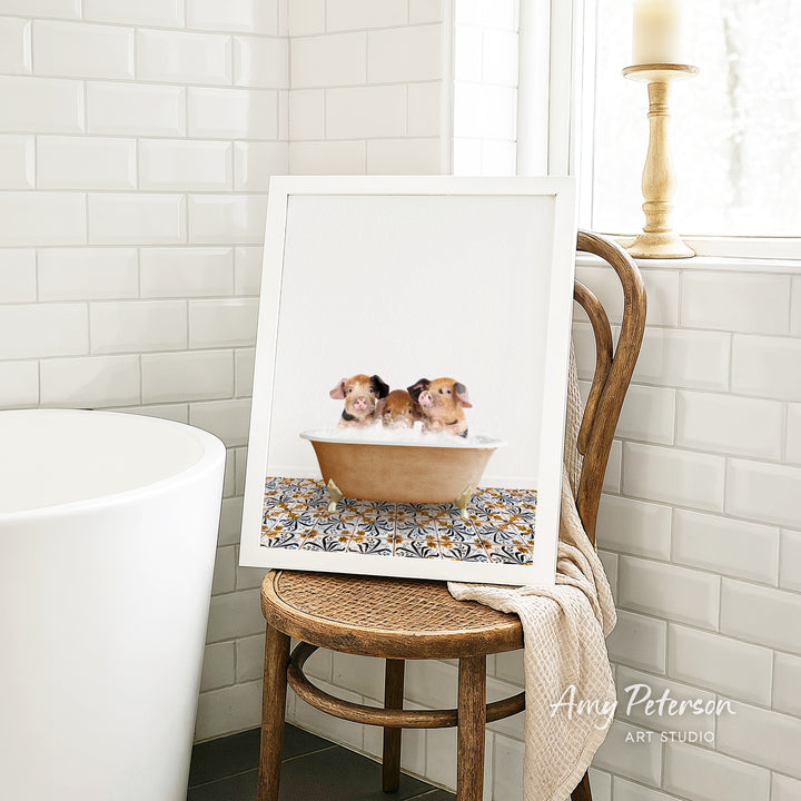 A framed image of two small brown and white dogs sitting in a bathtub, with a patterned tile design on the floor.