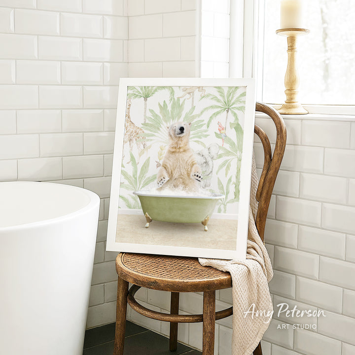 A framed image of a polar bear sitting in a bathtub, surrounded by tropical foliage, is displayed on a wooden chair in a bathroom setting.