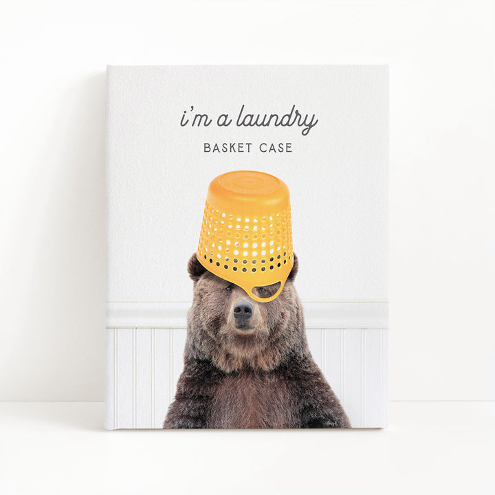 A bear wearing a yellow plastic basket on its head, with the text "I'm a laundry basket case" above the image.