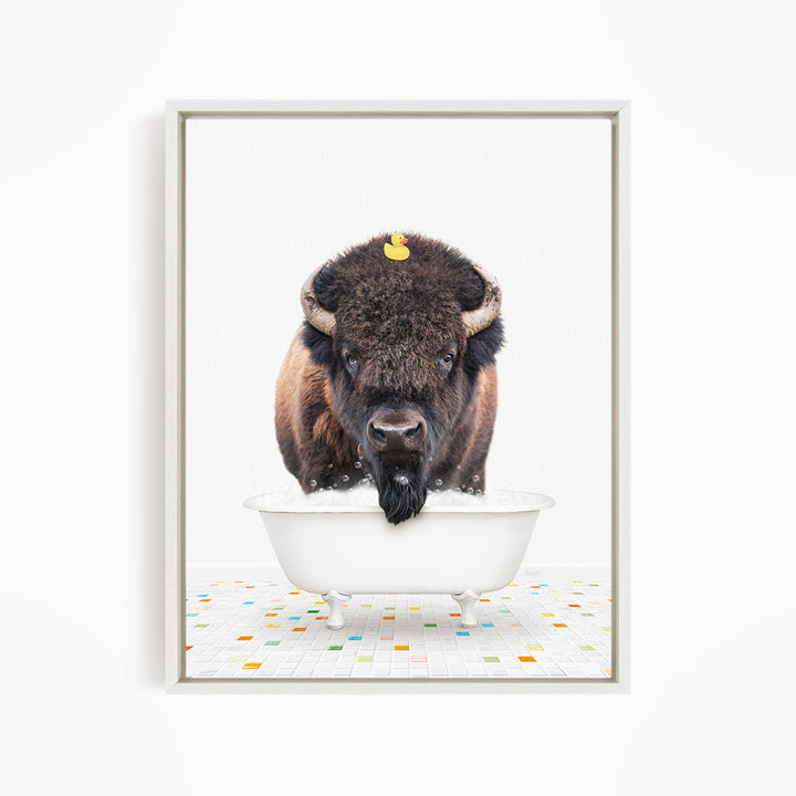 A buffalo with a yellow rubber duck perched on its head is standing in a white bathtub, surrounded by a colorful tiled floor.
