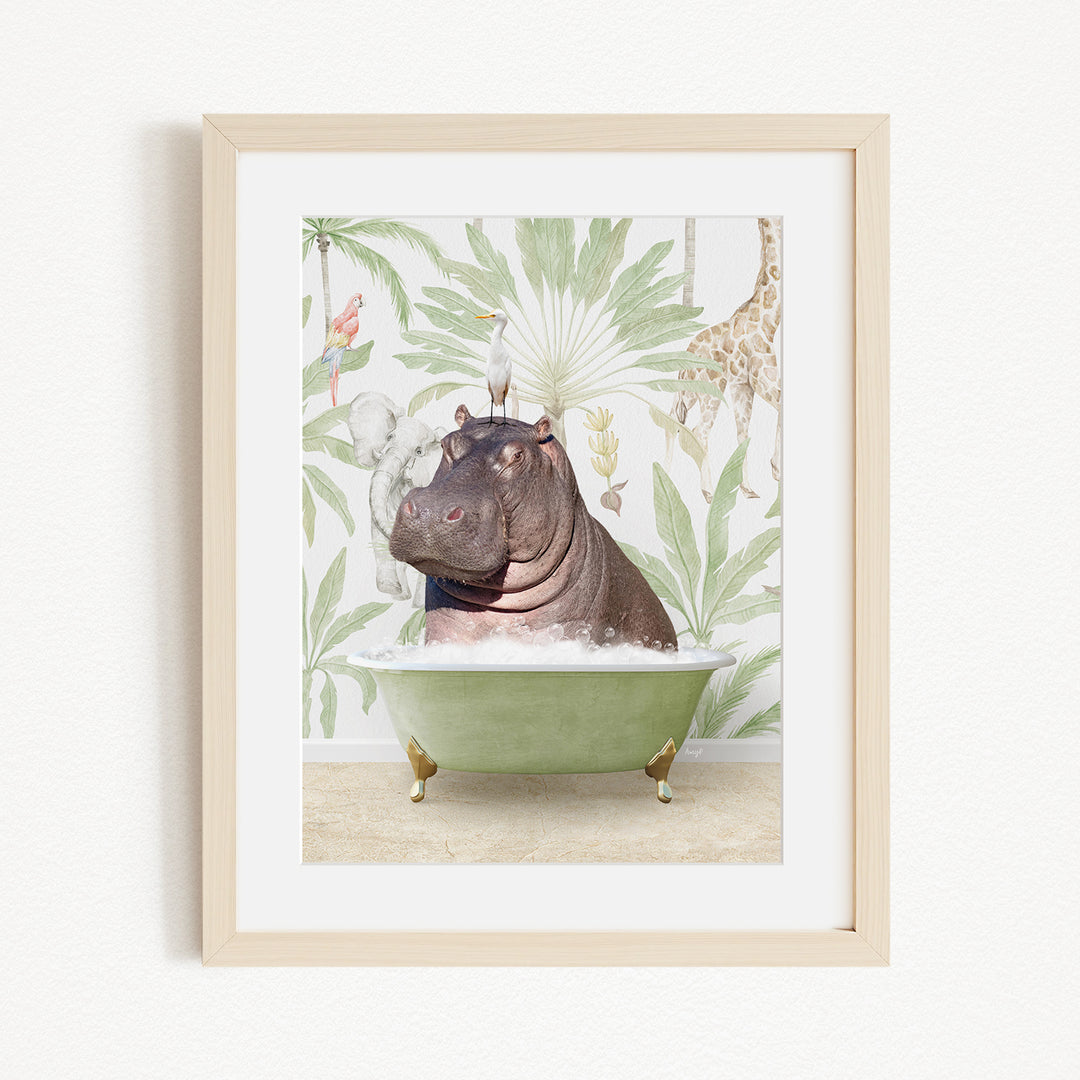 A framed image depicting a hippopotamus sitting in a green bathtub, surrounded by tropical foliage and a bird.