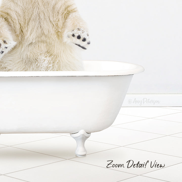 A polar bear cub sitting in a white bathtub, with its paws hanging over the edge.