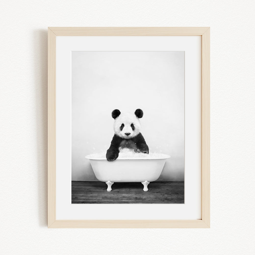 A panda bear sitting in a white bathtub filled with bubbles, creating a whimsical and playful scene.