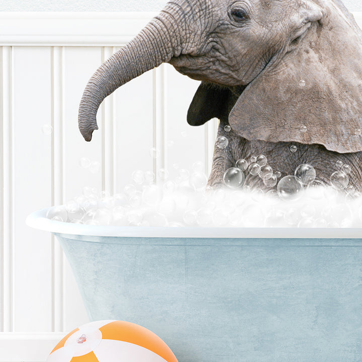 an elephant in a bathtub with bubbles and a beach ball