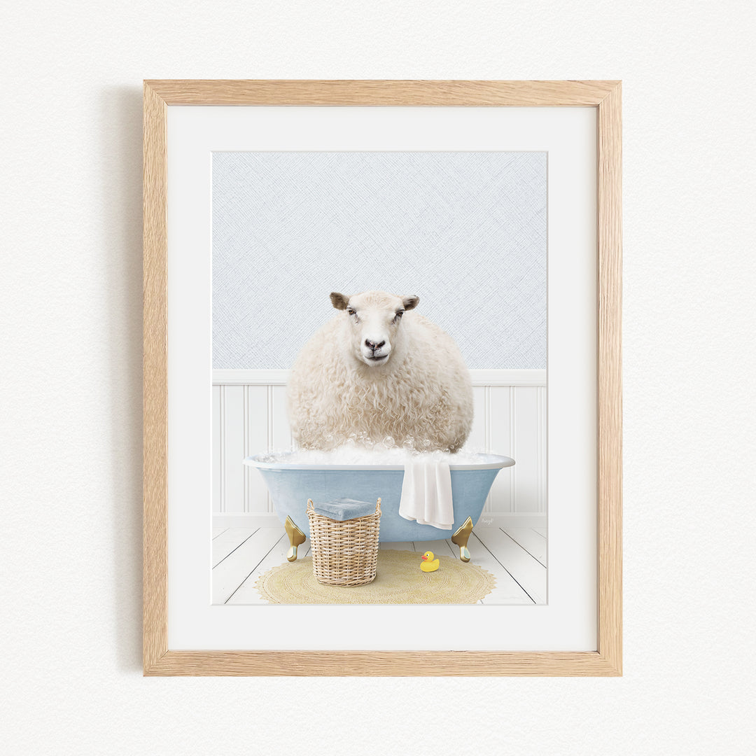 A fluffy white sheep sits in a blue bathtub filled with bubbles, surrounded by a yellow rubber duck and a basket.