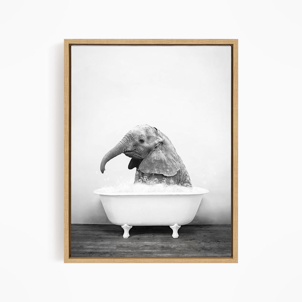 A baby elephant sitting in a bathtub filled with water, appearing to enjoy the bath.