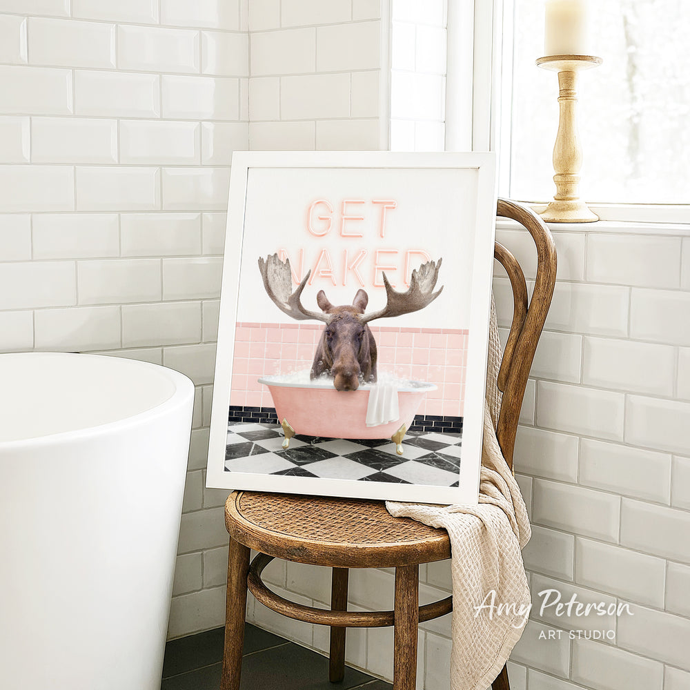 A framed image of a moose sitting in a pink bathtub, with the text "GET VAKED" displayed on the frame.