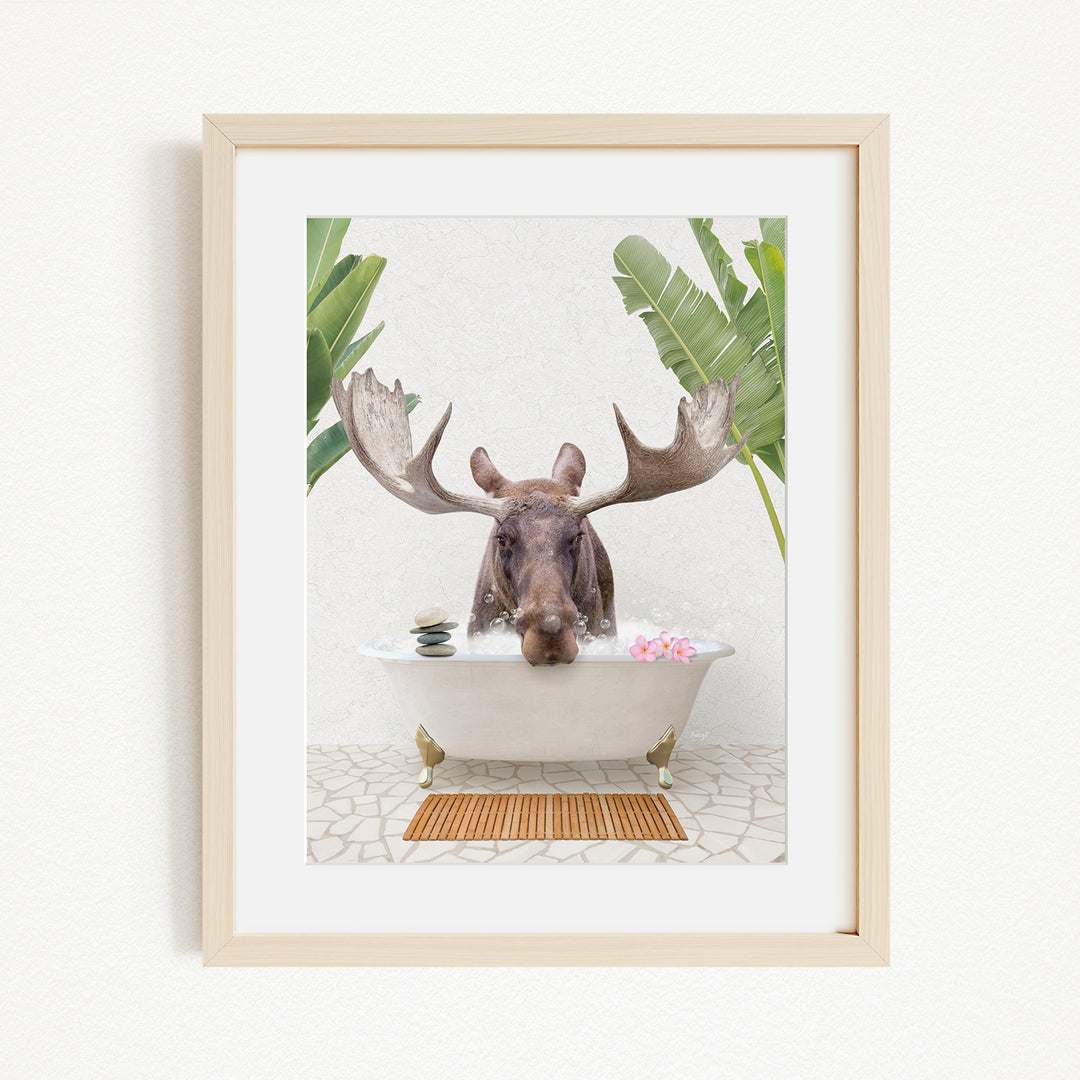 A moose with large antlers is sitting in a bathtub filled with water, surrounded by tropical plants.