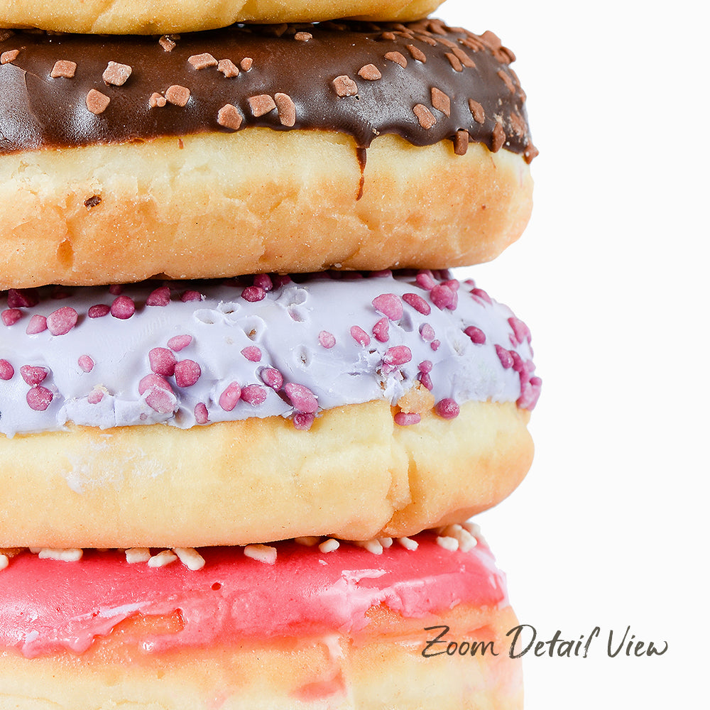 A close-up image of a stack of colorful donuts with various toppings and colors.