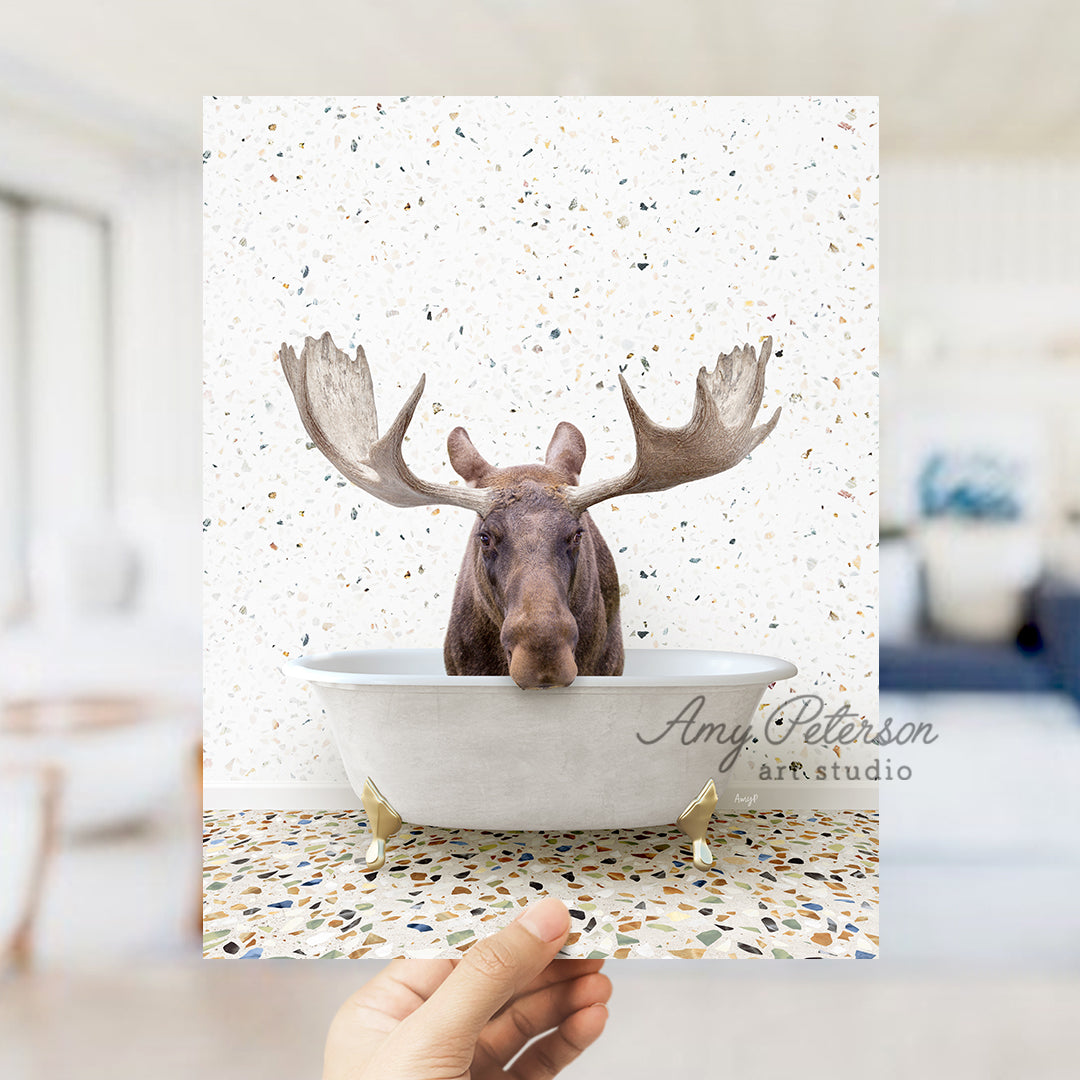 a hand holding up a card with a moose head in a bathtub