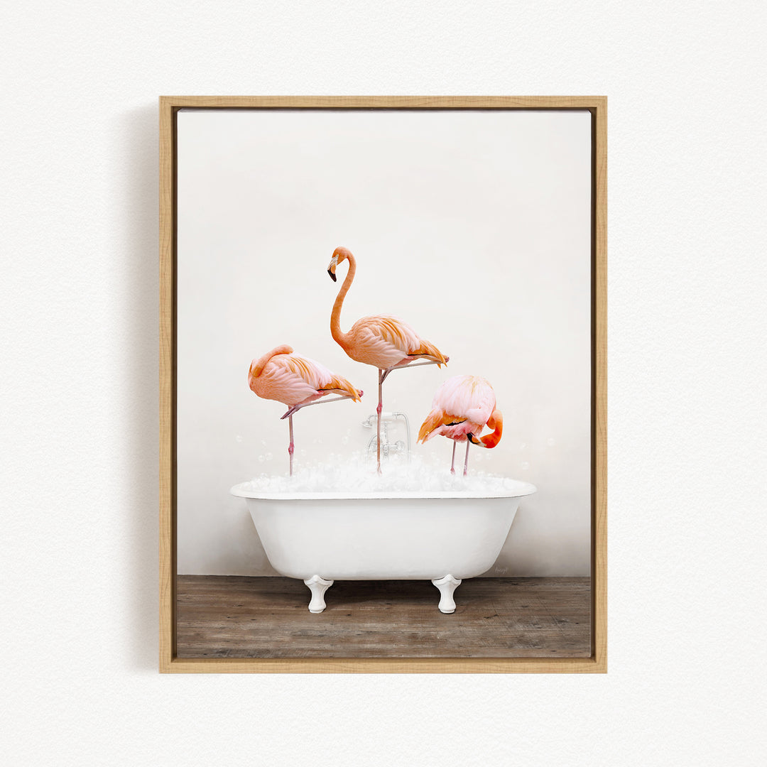 A framed image depicting three pink flamingos standing in a white bathtub filled with water.