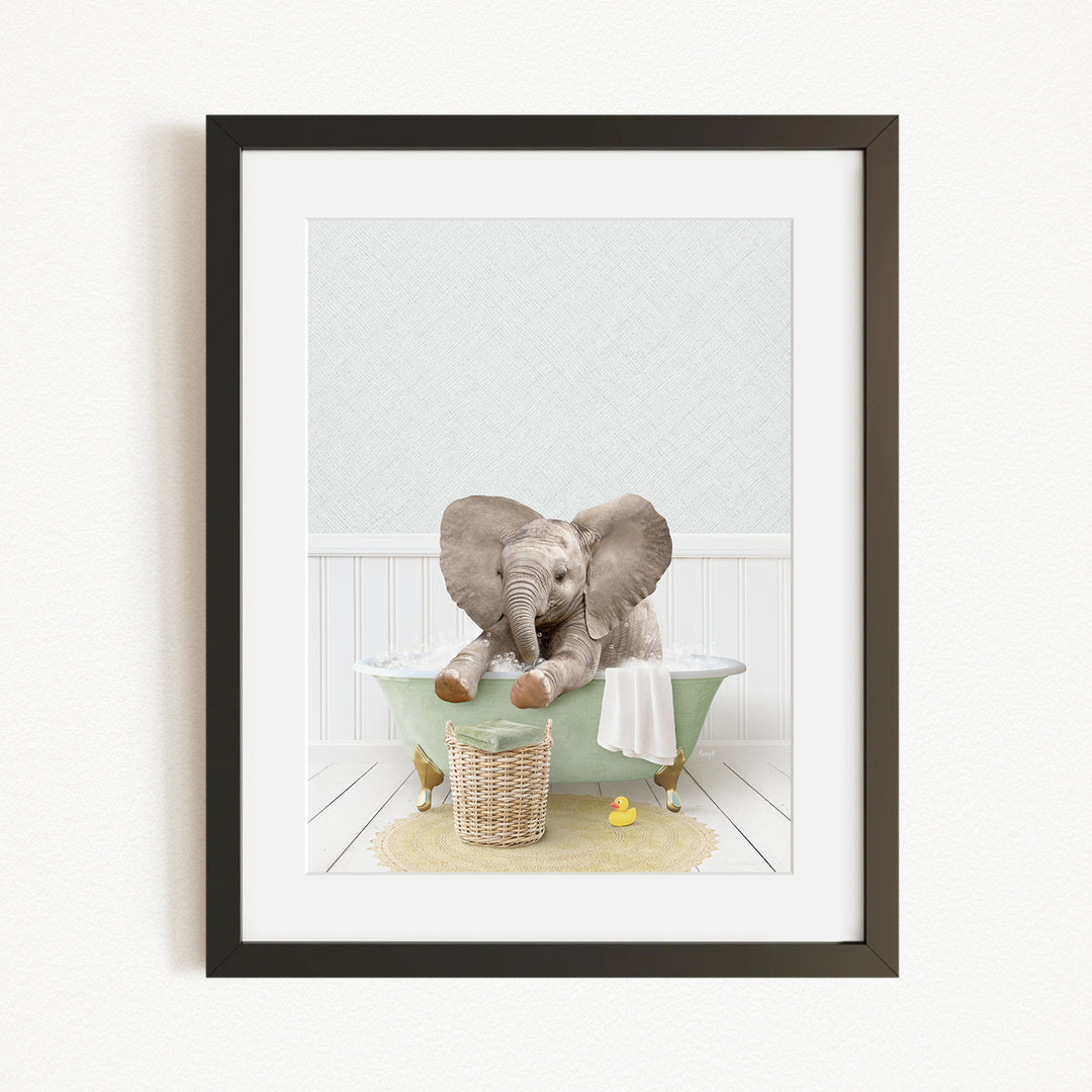 A baby elephant sitting in a green bathtub, surrounded by a basket of toys and a yellow rubber duck.