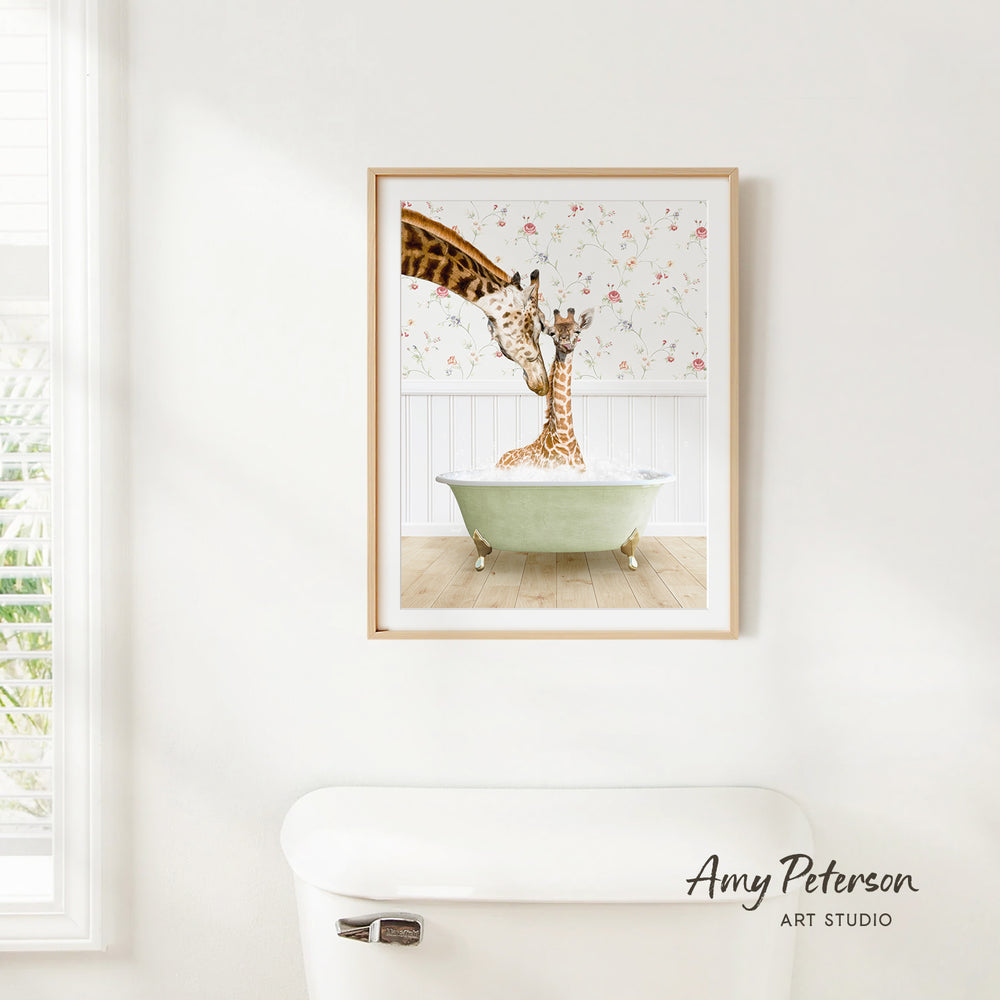 A framed image of two giraffes sitting in a green bathtub, with one giraffe extending its neck towards the other.