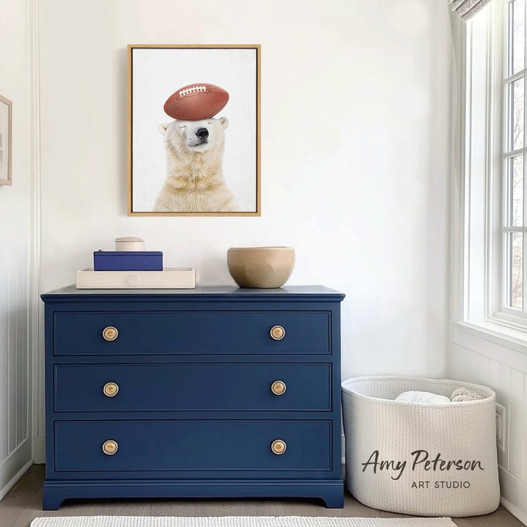 a blue dresser with a framed picture of a polar bear wearing a football hat on top of it. The dresser is situated in a room with a window and a white basket.