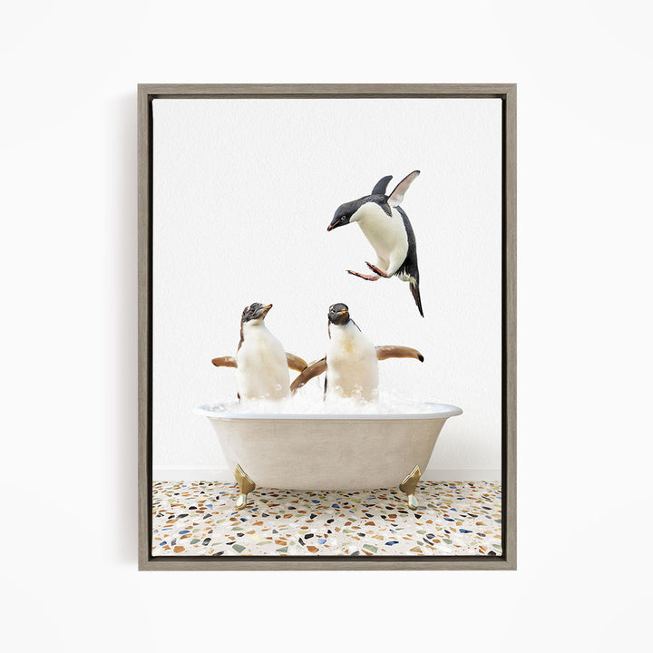 A framed image depicting two penguins standing in a bathtub filled with water, with one penguin flying towards the other.