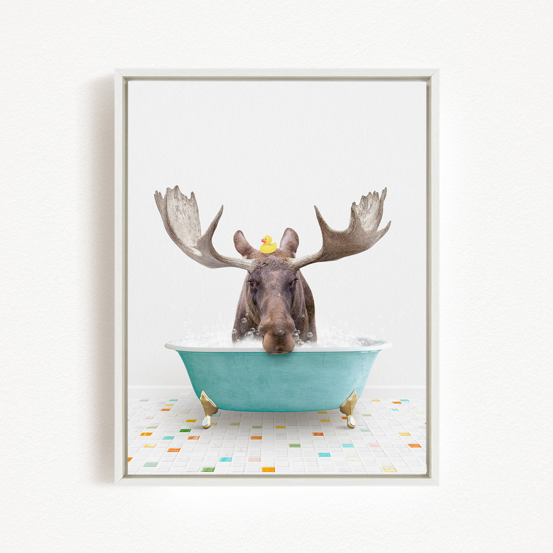 A moose with large antlers is sitting in a blue bathtub, with a rubber duck perched on its head.