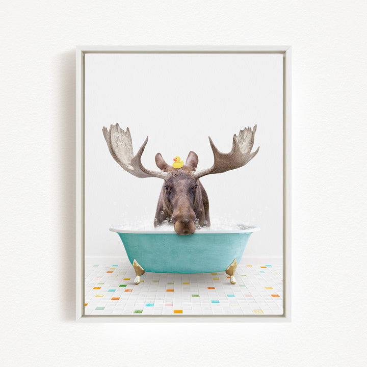 A moose with large antlers is sitting in a blue bathtub, with a rubber duck perched on its head.