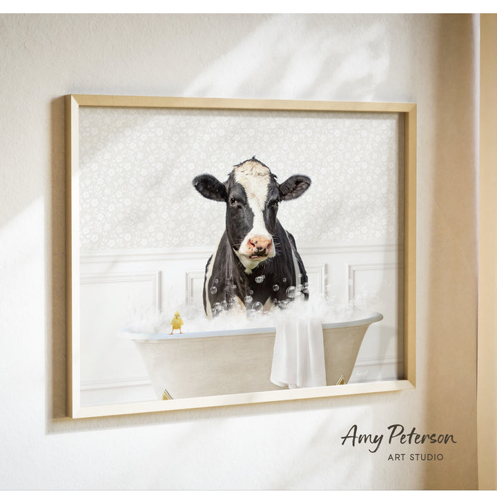 A black and white cow is sitting in a bathtub filled with bubbles, with a yellow bird perched on the edge of the tub.