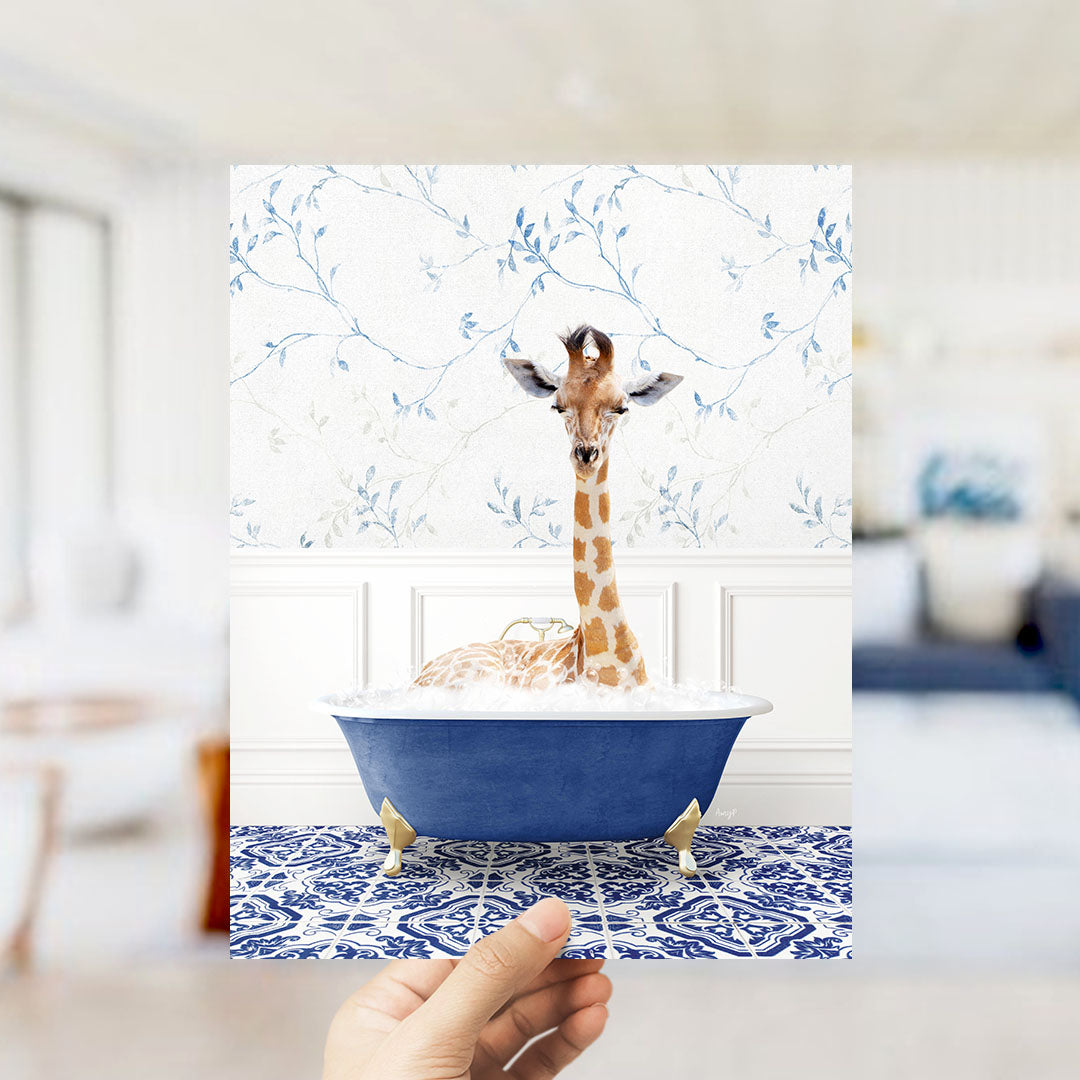 A giraffe sitting in a blue bathtub filled with bubbles, surrounded by a patterned blue and white rug.