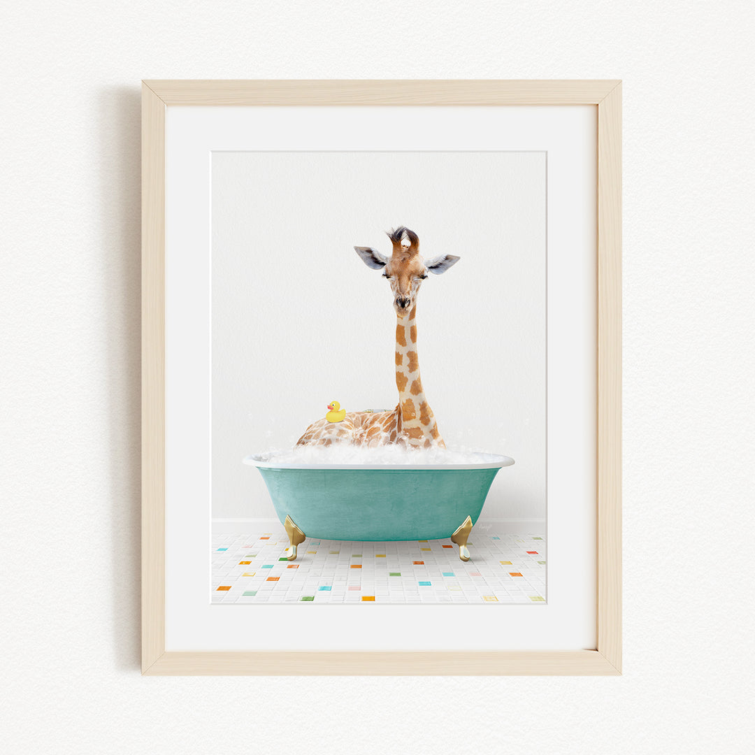 A giraffe is sitting in a green bathtub filled with bubbles, surrounded by a yellow rubber duck and a colorful patterned tile floor.