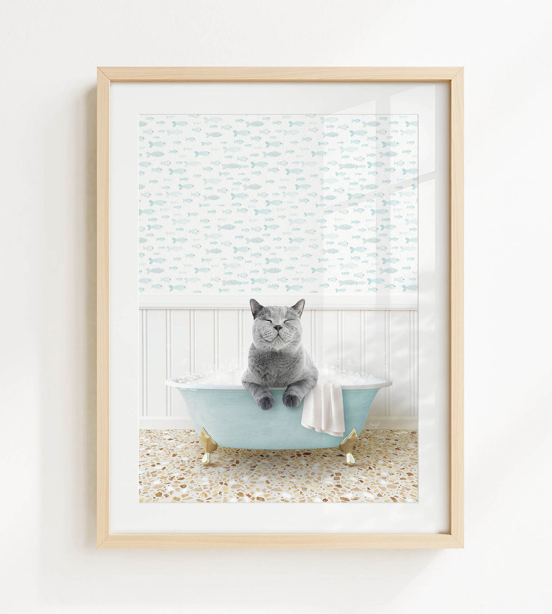 A gray cat sitting in a blue bathtub filled with bubbles, with a patterned shower curtain in the background.