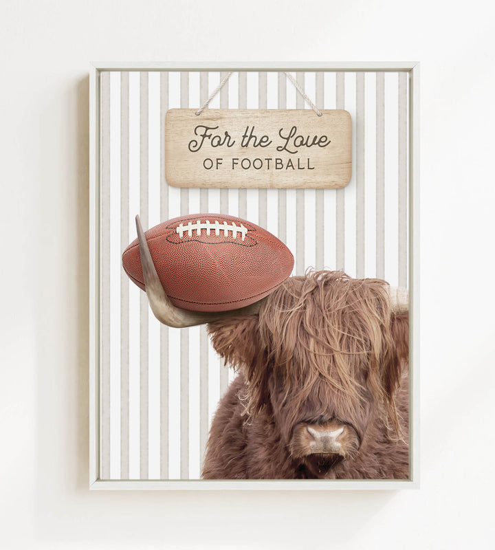 A framed image featuring a Highland cow with a football on its head, accompanied by a wooden sign that reads "For the Love of Football".
