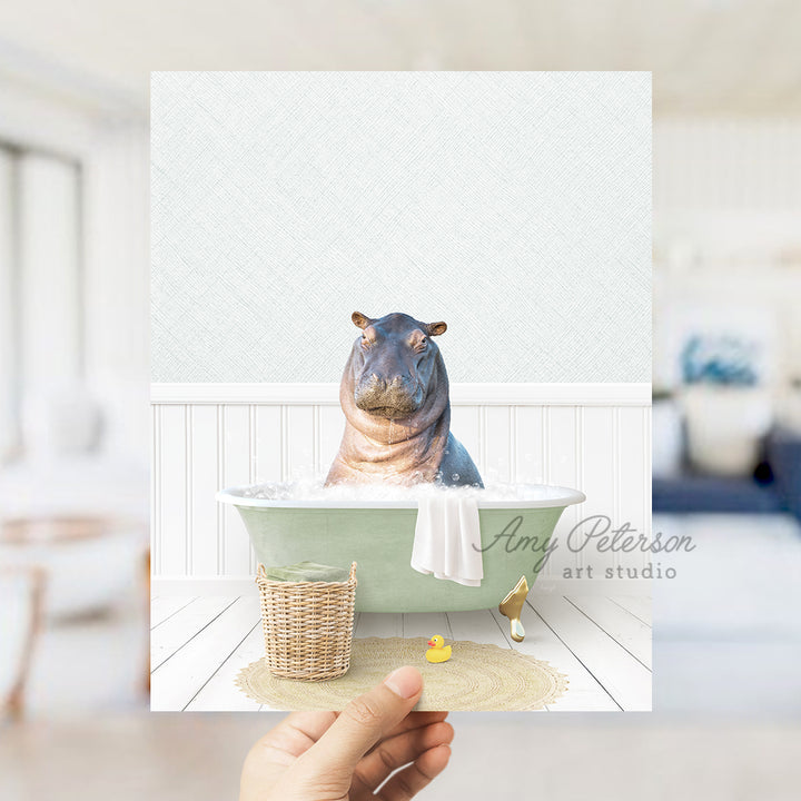 a person holding up a picture of a hippo in a bathtub