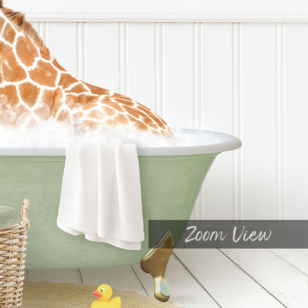 A giraffe is sitting in a green bathtub filled with water, surrounded by a yellow rubber duck and a white towel.