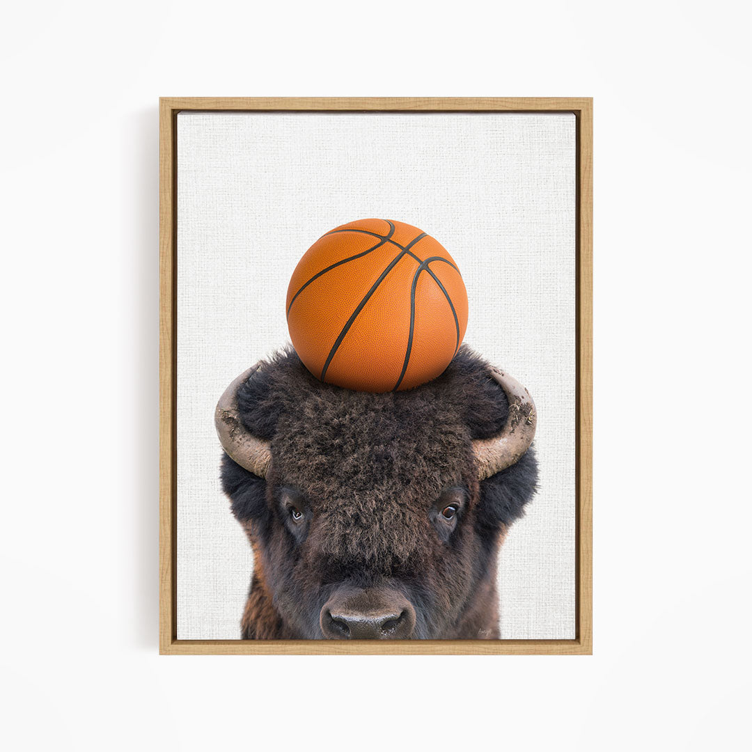 A buffalo with a basketball resting on its head.