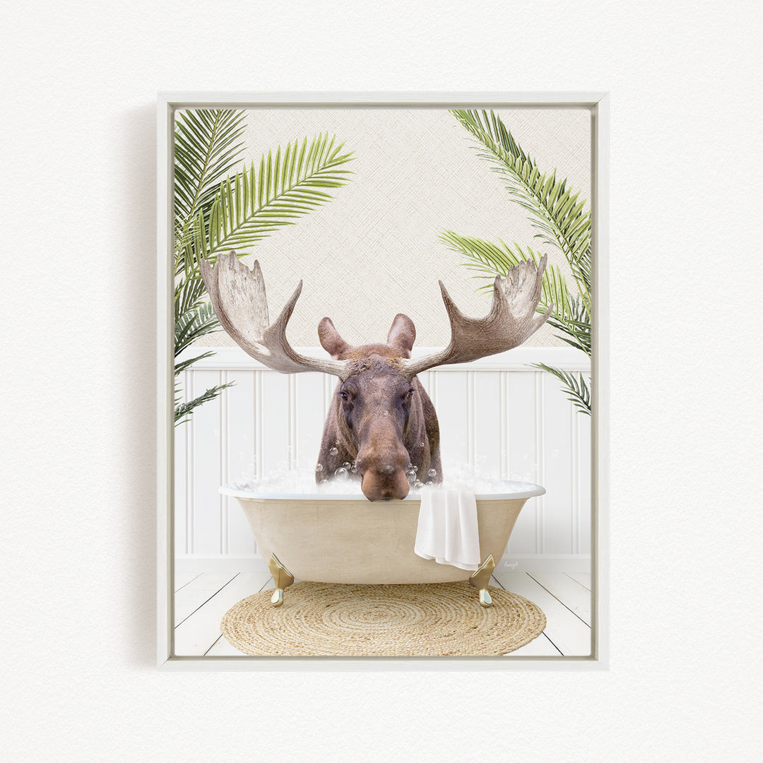 A moose with large antlers is sitting in a bathtub filled with water, surrounded by green plants.
