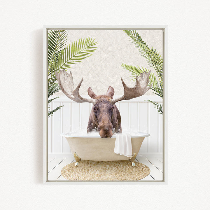 A moose with large antlers is sitting in a bathtub filled with water, surrounded by green plants.